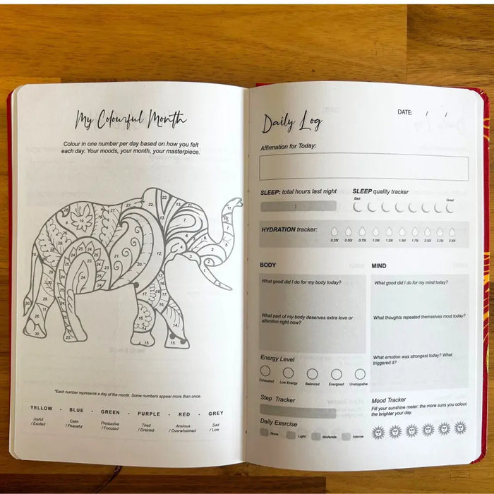 A red-bound wellness journal with an elephant design and daily tracking pages from the midnight blue wellness series