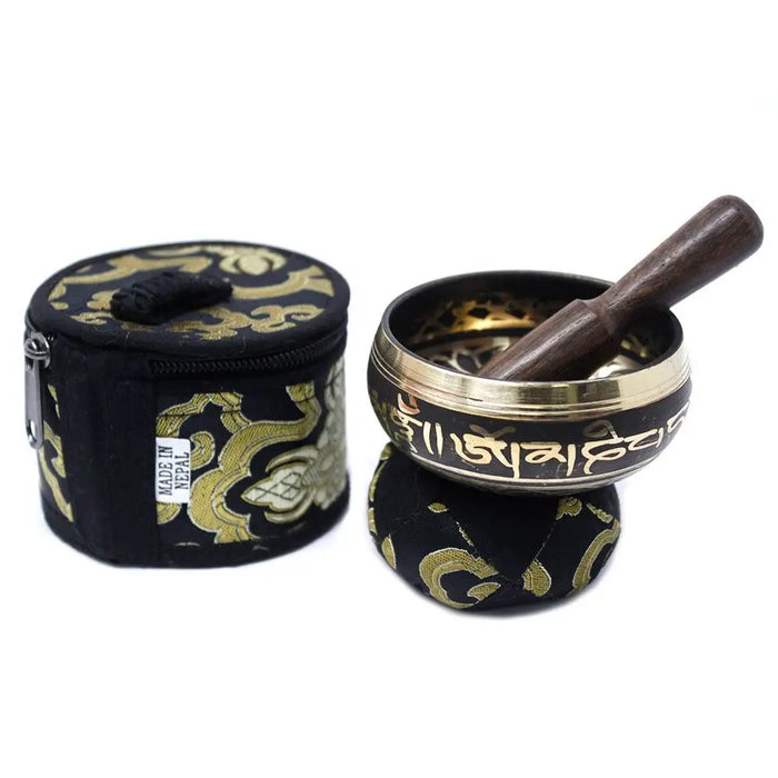 Black and gold mini singing bowl with engraved sanskrit script and wooden mallet in a mini singing bowl gift set
