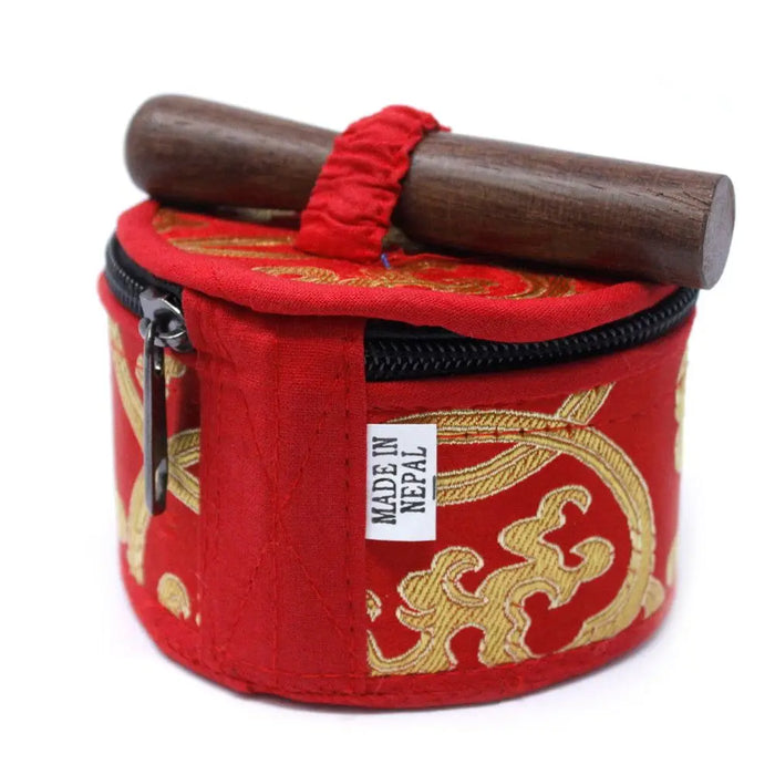 Red embroidered fabric case with gold patterns holding a dark wooden mallet for a mini singing bowl gift set