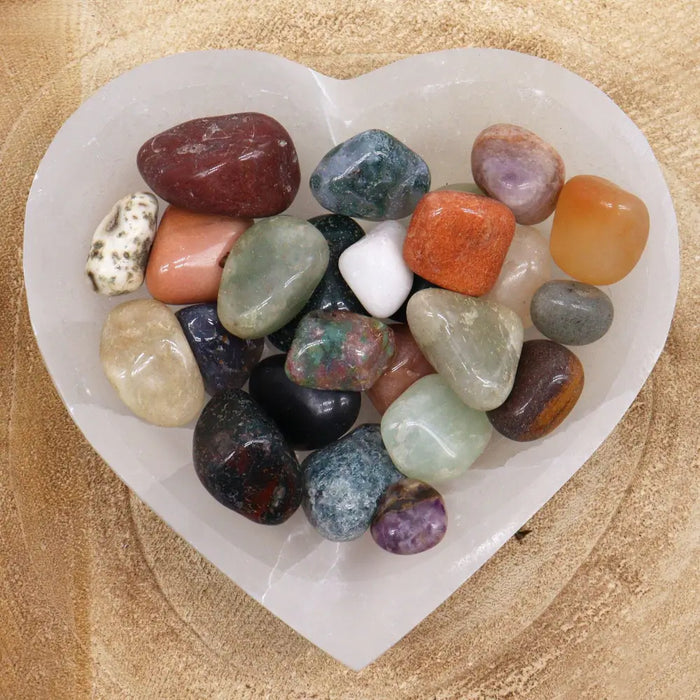 Heart-shaped white selenite dish holding a mix of polished multicolored gemstones 20-30mm weighing 1kg