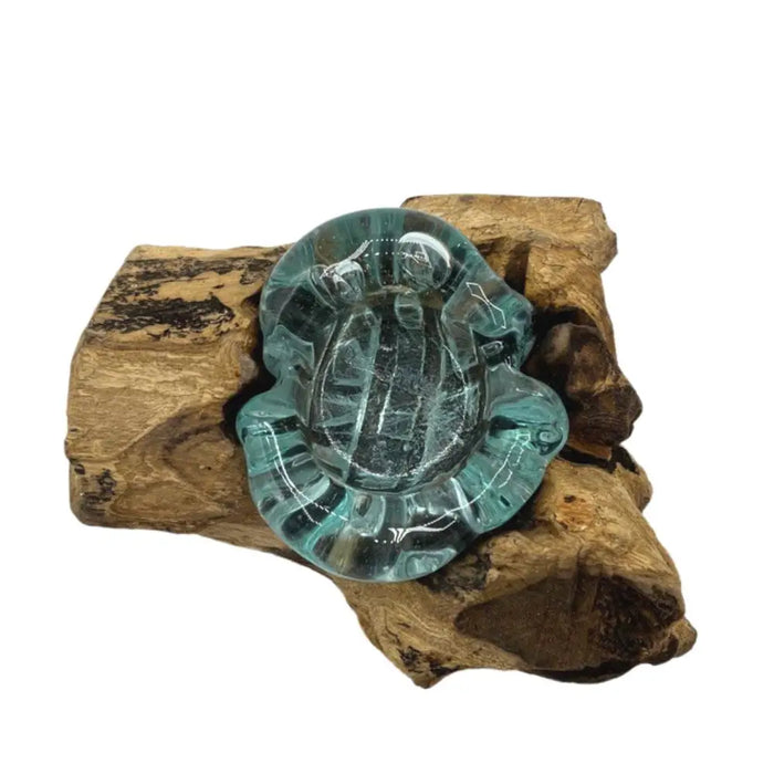 A translucent teal glass turtle-shaped tealight holder with detailed shell carvings and gamal wood accents