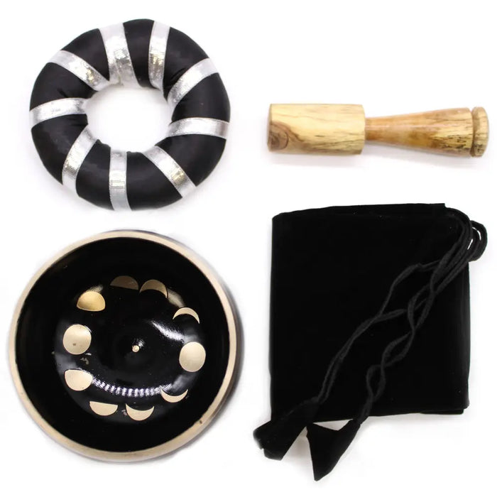 Black singing bowl set with gold moon phase design inside used to release negative emotions and for meditation