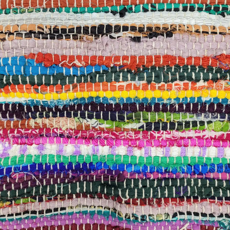 A vibrant multi-coloured dari rag rug made from recycled fabric strips woven in a patchwork pattern