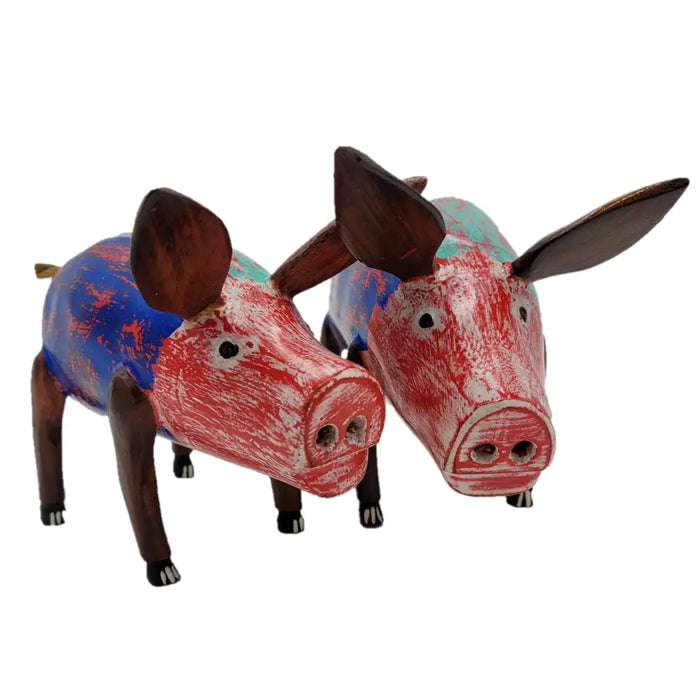 Two hand-painted wooden pig ornaments with red and blue distressed paint and dark brown ears and legs