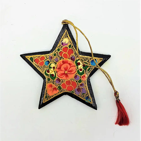A vibrant hand-painted papier maché star-shaped bauble with black border and intricate red orange purple floral designs