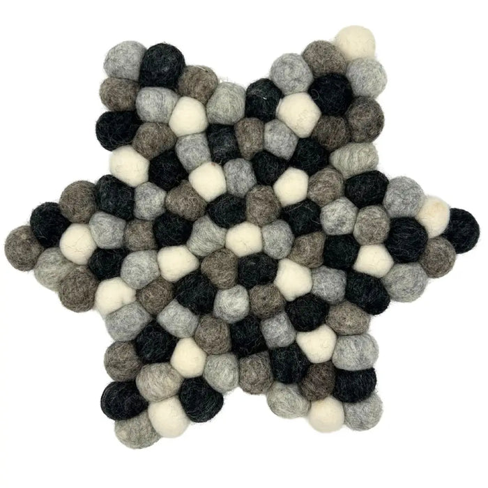 A star-shaped multi-grey felt ball centre mat made of fluffy wool balls in black white and shades of grey