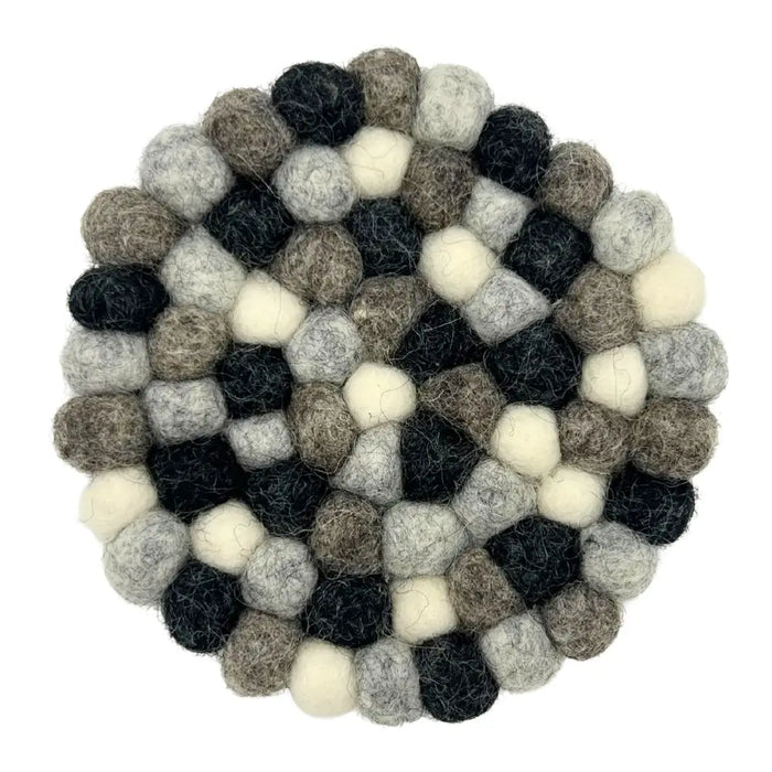 Round coasters made of interlocking black white and grey wool felt balls in a set of four
