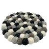 Round multi-grey felt ball placemat made of tightly arranged woolen balls in black white and gray shades
