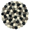 Round multi-grey felt ball placemat made of interlocking black white and gray wool balls