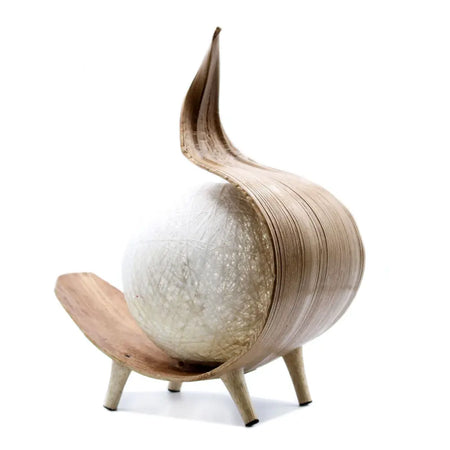A natural coconut lamp with a white textured spherical body and layered light wood slats with a leaf-like top finial