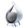 Natural coconut lamp with grey textured sphere inside a wood-grain curved frame on three slender legs