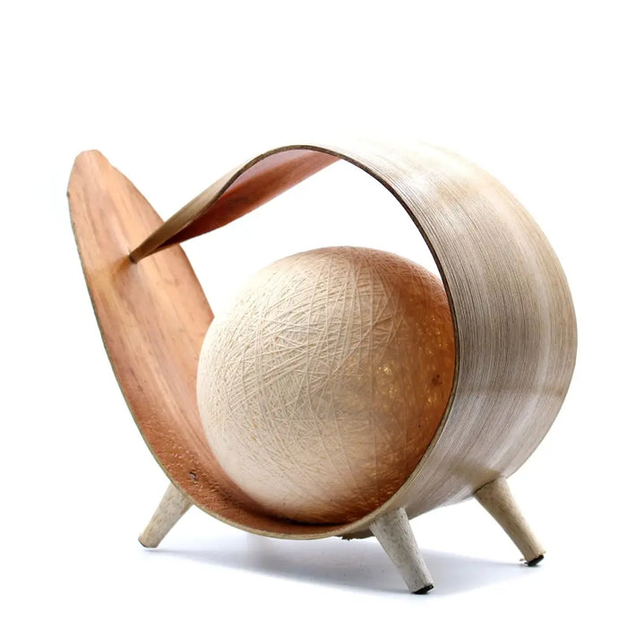 A mid-century modern wooden natural coconut lamp with a curved open-shell design holding a textured spherical orb
