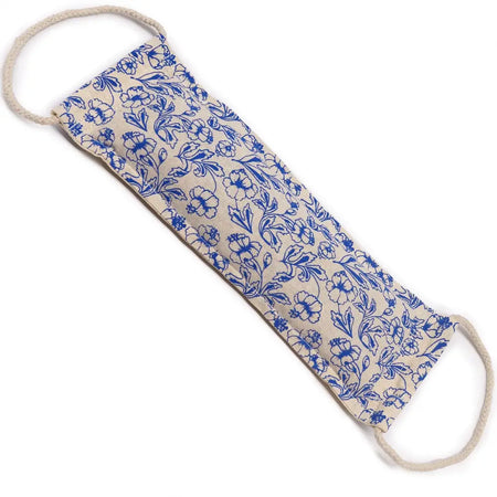 A beige cotton foot soak bag with blue floral pattern and wheat filling with reinforced rope handles