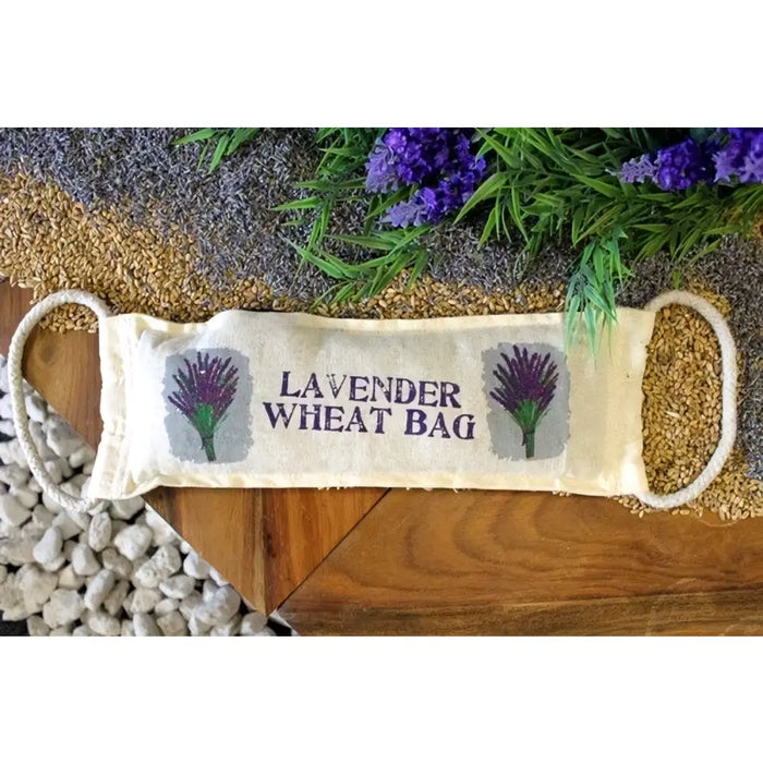 A beige linen lavender wheat bag with purple floral embroidery and white rope handles filled with golden grains