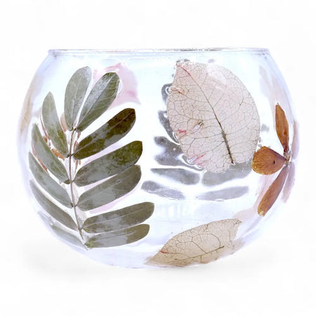 Clear glass bowl candle holder with preserved leaves in green and brown shades made from recycled glass for natural decor