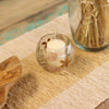Natural floral glass bowl candle holder made of recycled glass with pink and brown pressed flowers holding white candle