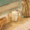 Natural floral glass large bowl candle holder in clear recycled glass with dried flowers and golden leaves holding white candle
