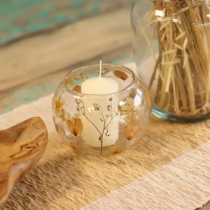 Natural floral glass large bowl candle holder in clear recycled glass with dried flowers and golden leaves holding white candle
