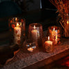 Set of five amber recycled glass candle holders with leaf and heart designs in varying heights for natural floral decor