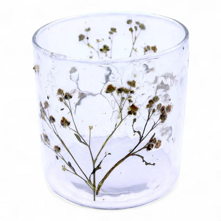 Clear glass candle holder with dried baby’s breath flowers embedded in recycled glass textured surface