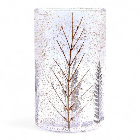 Clear glass candle holder made of recycled glass with embedded dried brown branches and silver ferns in natural floral design