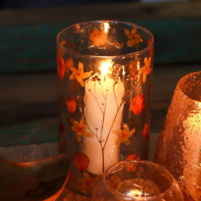 Natural floral glass tall vase candle holder made of clear recycled glass with dried orange and yellow flowers embedded