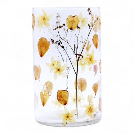 Clear cylindrical glass candle holder with preserved yellow and beige flowers in recycled glass resin vase