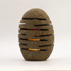 Natural riverstone candle holder shaped like a brown standing stone with slits glowing warm orange light