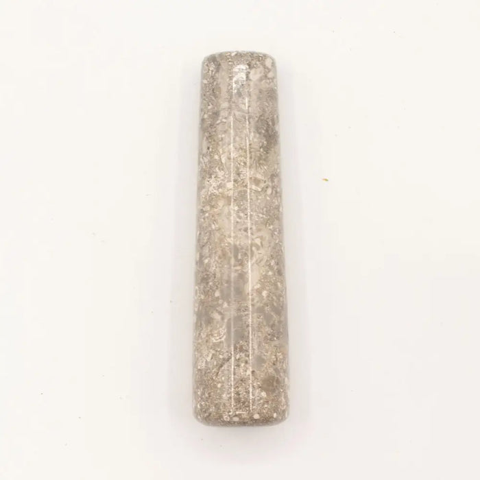A textured translucent gray natural riverstone pestle with speckled surface and subtle vertical lines