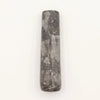 A dark gray natural riverstone pestle with smooth surface and natural veining patterns for mortar use