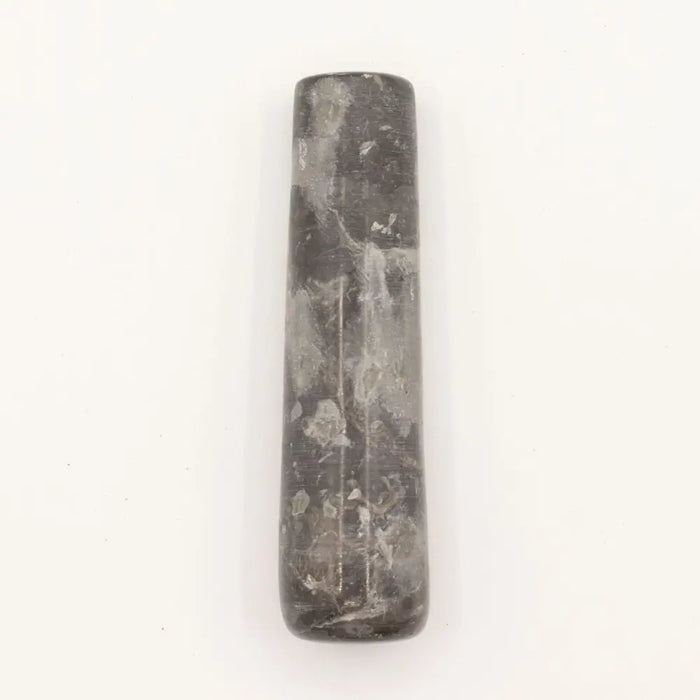 A dark gray natural riverstone pestle with smooth surface and natural veining patterns for mortar use