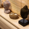 Natural riverstone tealight holder in earthy brown with rough texture and two circular indentations for candles