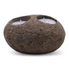 Natural riverstone tealight holder in dark brown with rough texture and two white tealights in circular indentations