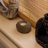 A round textured gray riverstone tealight holder with a smooth interior for natural candle display