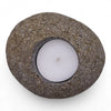 Rounded gray riverstone tealight holder with smooth speckled texture holding a white candle