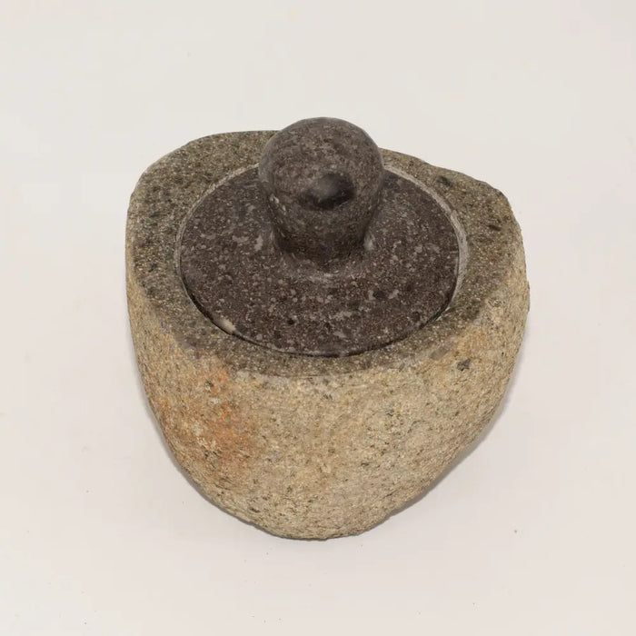 Natural riverstone trinket pot medium with rough textured weathered stone mortar and dark gray pestle inside