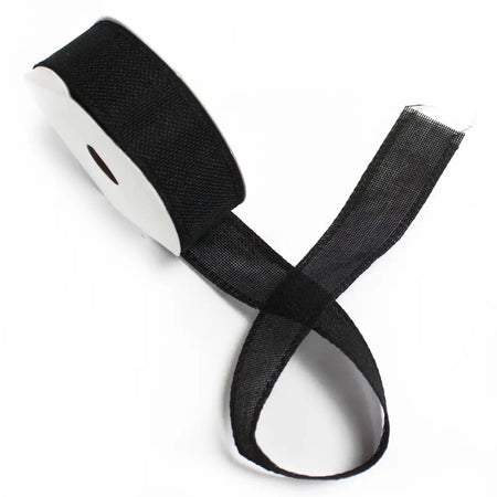 Black woven ribbon with natural texture wound on a white spool for crafting and decoration use