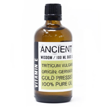 An amber glass bottle with black cap labeled ancient wisdom 100ml base oil natural vitamin e oil with wheat germ