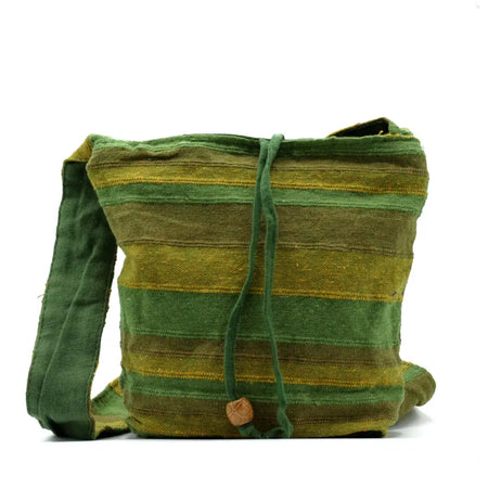 A handwoven nepal sling bag in green and olive stripes with a wooden toggle, ideal for summer beach use