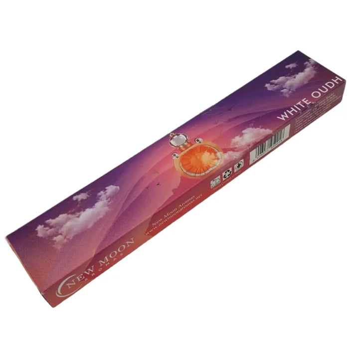 Purple and pink cardboard box of New Moon Aromas white oudh incense sticks with golden pocket watch and sky backdrop