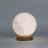 New wave lamp moon is a white moon-shaped lamp with detailed craters and a light wood base