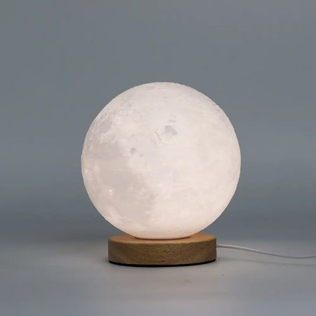 New wave lamp moon is a white moon-shaped lamp with detailed craters and a light wood base