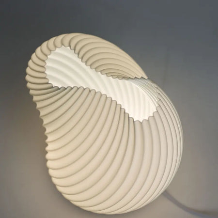 Cream-colored shell twisted lamp with ribbed texture and smooth curved design made from a soft shell material