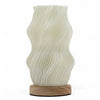 New wave lamp star twisted with cream ceramic wave pattern and natural wood base on a plain background