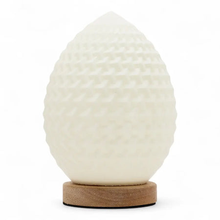 A white egg shaped wave lamp with a textured surface sits on a round wooden base called new wave lamp teardrop