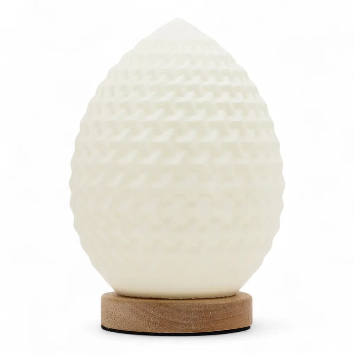 A white egg shaped wave lamp with a textured surface sits on a round wooden base called new wave lamp teardrop