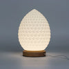 White textured egg-shaped wave lamp with wooden base, designed as a teardrop shape for ambient lighting