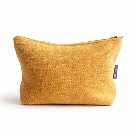A mustard-yellow jacquard toiletry bag with zipper and black tag for organizing everyday essentials from marigold loom