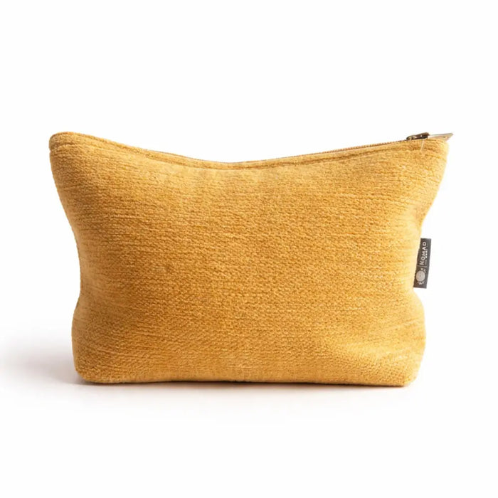 A mustard-yellow jacquard toiletry bag with zipper and black tag for organizing everyday essentials from marigold loom