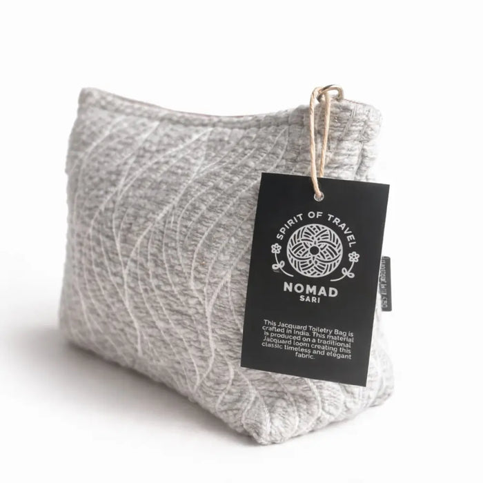Gray jacquard toiletry bag with woven moonlit weave pattern and nomad sari black tag for travel use